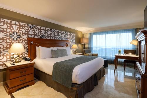 a hotel room with a large bed and a piano at Villahermosa Marriott Hotel in Villahermosa