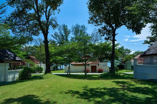 a yard with two trees and a house at The Westin Langkawi Resort & Spa in Kuah