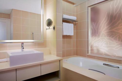 a bathroom with a sink and a bath tub at The Westin Langkawi Resort & Spa in Kuah