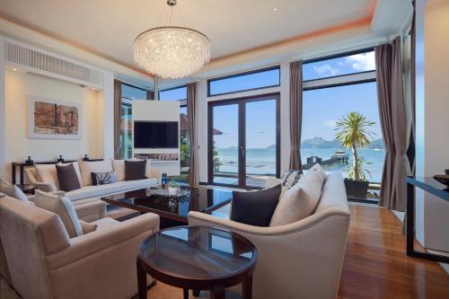a living room with white furniture and large windows at The Westin Langkawi Resort & Spa in Kuah