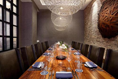 a long table in a restaurant with chairs and a chandelier at JW Marriott Minneapolis Mall of America in Bloomington