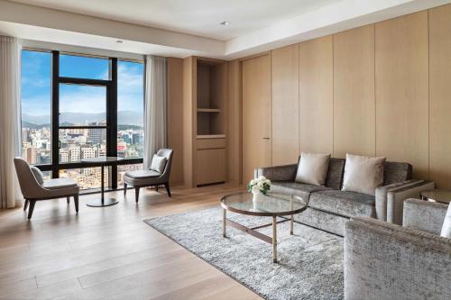 a living room with a couch and a table at Taipei Marriott Hotel in Taipei