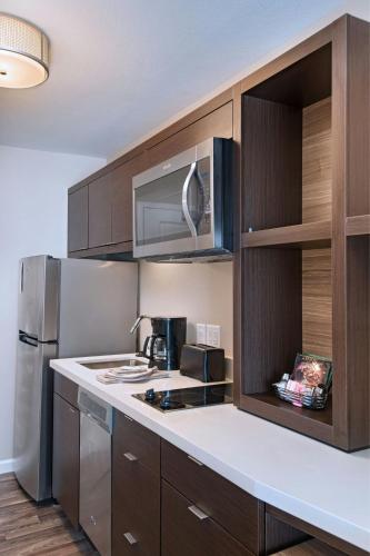 una cucina con mobili in legno e un frigorifero in acciaio inossidabile di TownePlace Suites by Marriott Lakeland a Lakeland