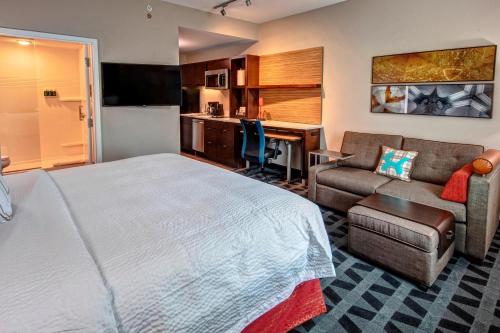 a hotel room with a bed and a couch and a desk at TownePlace Suites by Marriott Hot Springs in Hot Springs