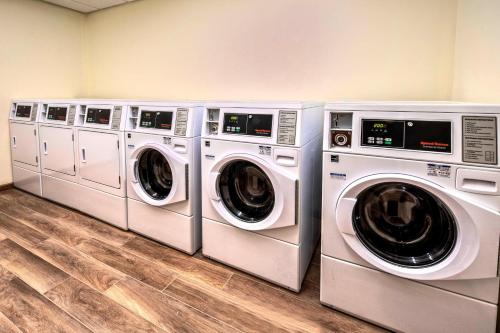 three washing machines are lined up in a laundry room at TownePlace Suites by Marriott Hot Springs in Hot Springs
