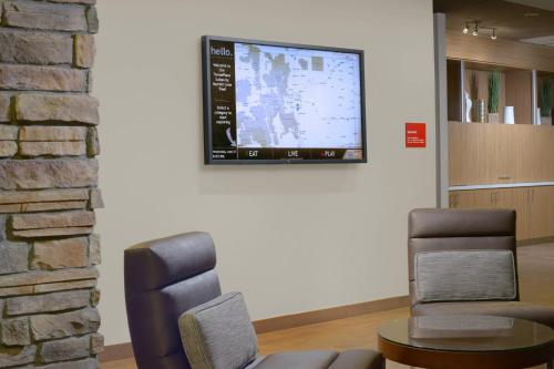 a waiting room with two chairs and a flat screen tv at TownePlace Suites by Marriott Denver South/Lone Tree in Lone Tree