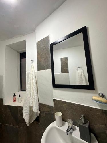 une salle de bains avec un lavabo et un miroir dans l'établissement Helen House, à Bogotá