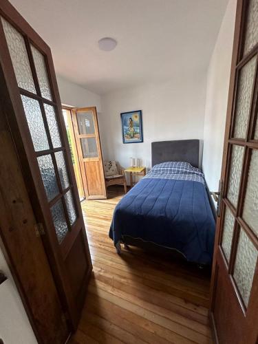 une chambre avec un lit recouvert d'une couette bleue dans l'établissement Helen House, à Bogotá