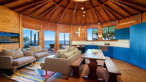 a large living room with a table and chairs at 'The Yurt' by HolidayCo in Hardys Bay