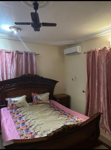 a bed in a bedroom with a ceiling fan at Paradise Estate in Gambia in Old Yundum