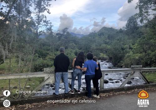 a group of people standing on a bridge overlooking a river at Hotel Agata Boutique pinares Pereira in Pereira