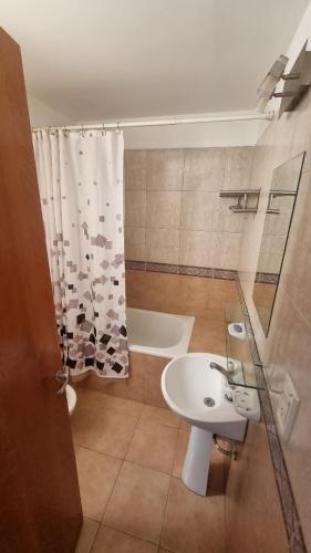 a bathroom with a sink and a shower curtain at Depto Velez Sarsfield in Cipolletti