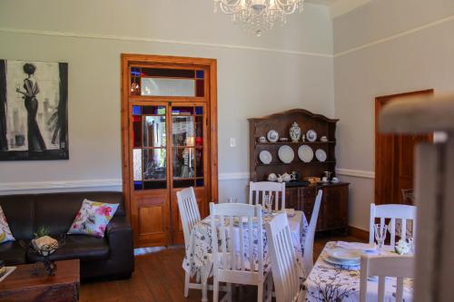 uma sala de estar com uma mesa e cadeiras e um lustre em Carmel Villa B&B or Self-Catering em Calvinia
