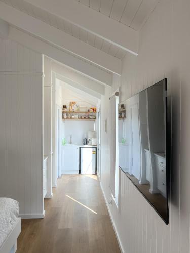 a room with a hallway with a television on a wall at Banjos Cabin Gippsland - Luxury Eco Stay - King Bed, Pond Valley Views, Fireplace in Seaton