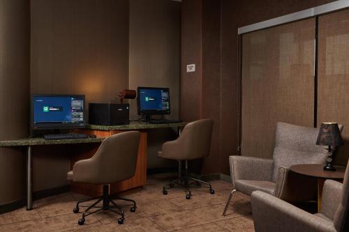 a waiting room with two computer monitors and chairs at SpringHill Suites by Marriott Baton Rouge North / Airport in Baton Rouge