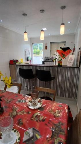 a dining room with a table with a red table cloth at Casa de Praia em Unamar Cabo Frio 6 pessoas in Cabo Frio