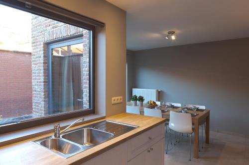 eine Küche mit einem Waschbecken und einem großen Fenster in der Unterkunft FLY in POPS in Poperinge