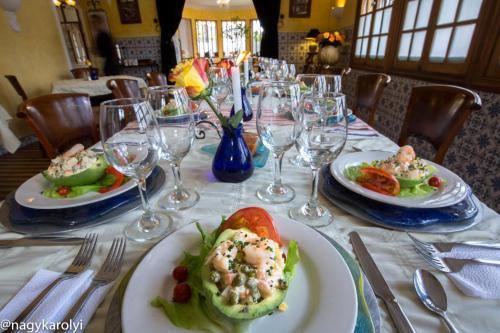 a table with plates of food and wine glasses at Hotel Boutique Cultura Manor by Café Cultura in Quito