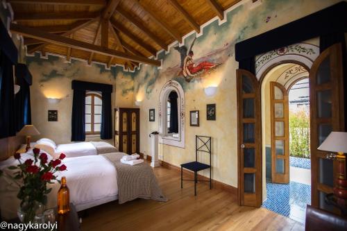 a bedroom with a bed and a painting on the wall at Hotel Boutique Cultura Manor by Café Cultura in Quito