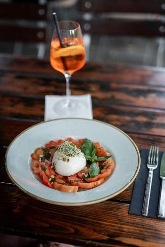 a plate of food with an egg on a table with a drink at Sheraton Essen Hotel in Essen