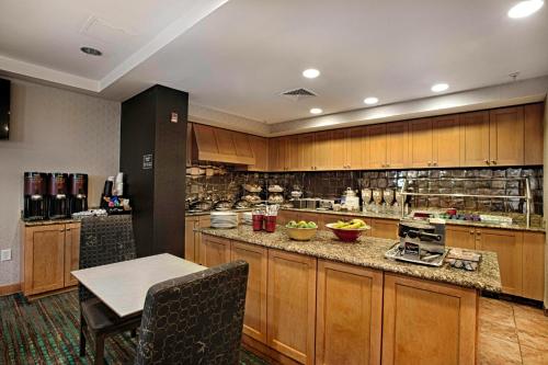 a large kitchen with wooden cabinets and a table at Residence Inn by Marriott Atlantic City Airport Egg Harbor Township in Egg Harbor Township