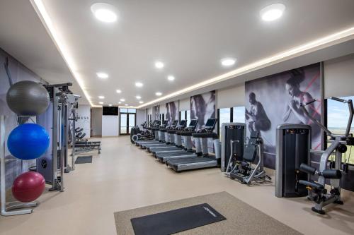 a gym with a row of tread machines at Madison Marriott West in Middleton