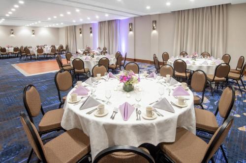 a conference room with tables and chairs with flowers on them at Madison Marriott West in Middleton