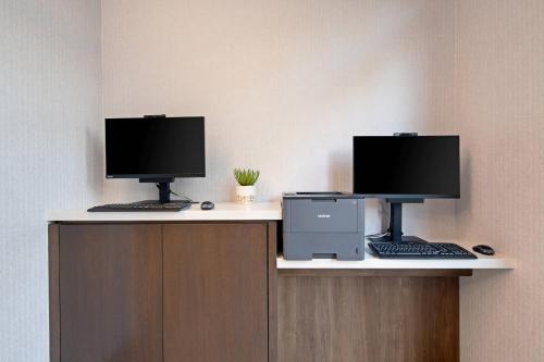a desk with two computer monitors and a printer at SpringHill Suites by Marriott Valencia in Valencia