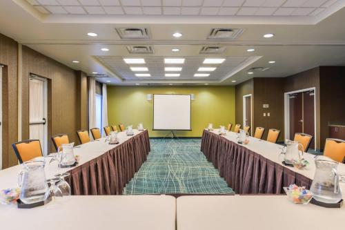a conference room with tables and chairs and a whiteboard at SpringHill Suites Arundel Mills BWI Airport in Hanover