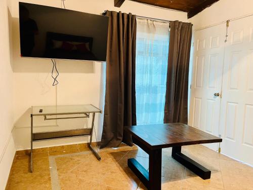 a living room with a table and a tv on the wall at Venator House Habitación sencilla #16 in Miravalle