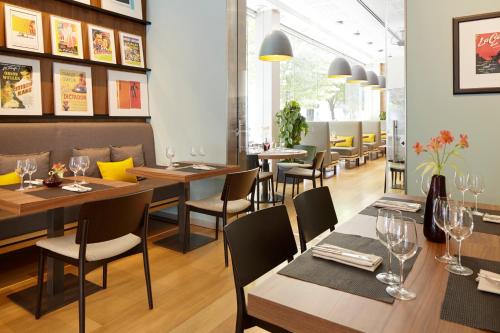 a restaurant with wooden tables and chairs and windows at Hotel Zinema7 in Donostia-San Sebastián