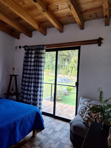 a bedroom with a bed and a sliding glass door at Casa Elizabeth en valle de Bravo,Avandaro in Godínez