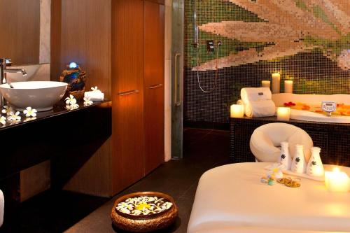 a bathroom with a toilet and a sink with candles at The Westin Hyderabad Mindspace in Hyderabad