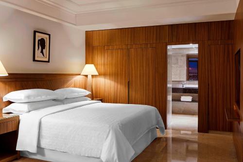 a bedroom with a white bed and a bathroom at Sheraton Tunis Hotel in Tunis