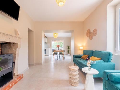a living room with a blue couch and a fireplace at Charming Holiday Home with Private Pool in Hautefort