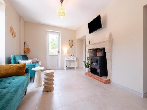 a living room with a blue couch and a fireplace at Charming Holiday Home with Private Pool in Hautefort