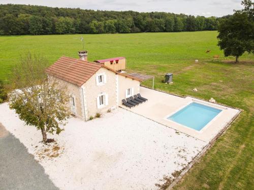 an aerial view of a small house with a swimming pool at Charming Holiday Home with Private Pool in Hautefort