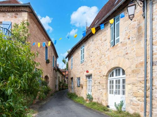 an alley in an old stone building with flags at Charming Holiday Home with Private Pool in Hautefort