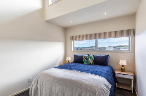 a bedroom with a bed and a window at The Lake House in Taupo
