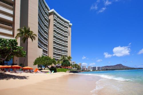 a beach in front of a hotel and the ocean at Sheraton Waikiki Beach Resort in Honolulu
