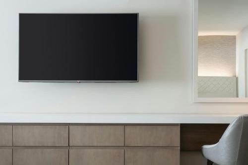 a television on a white wall in a living room at Sheraton Waikiki Beach Resort in Honolulu