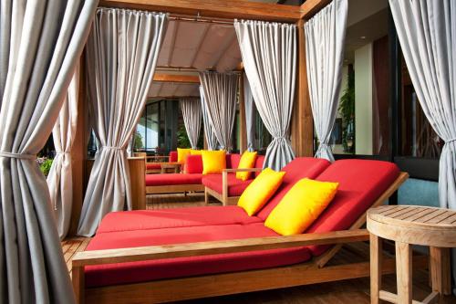 a red couch with yellow pillows on a porch at Sheraton Waikiki Beach Resort in Honolulu