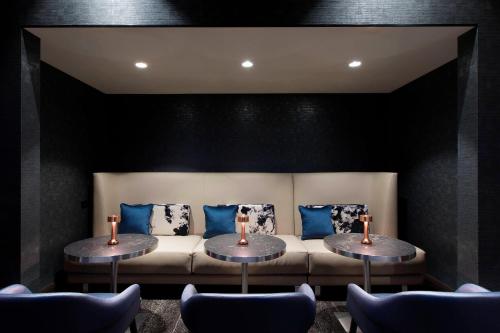 a living room with two tables and a couch at Sheraton Grand Sydney Hyde Park in Sydney