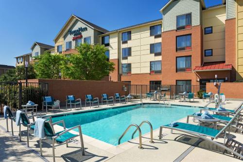 a swimming pool with chairs and a building at TownePlace Suites by Marriott Bossier City in Bossier City