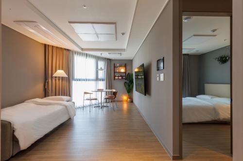 a hotel room with two beds and a table at Wecostay Chungmuro in Seoul