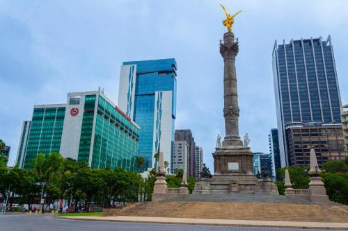 a statue in the middle of a city with tall buildings at Sheraton Maria Isabel Mexico City Reforma in Mexico City