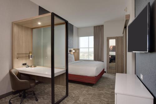 a hotel room with a bed and a desk and a sink at SpringHill Suites by Marriott Fort Lauderdale Miramar in Miramar