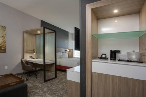 a hotel room with a bed and a kitchen at SpringHill Suites by Marriott Fort Lauderdale Miramar in Miramar