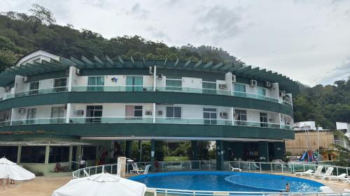 Un gran edificio con una piscina en frente. en angra dos reis, condomínio angra inn, en Angra dos Reis