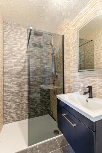a bathroom with a glass shower and a sink at Beautiful 3 bedroom house with garden + Parking in Oxford